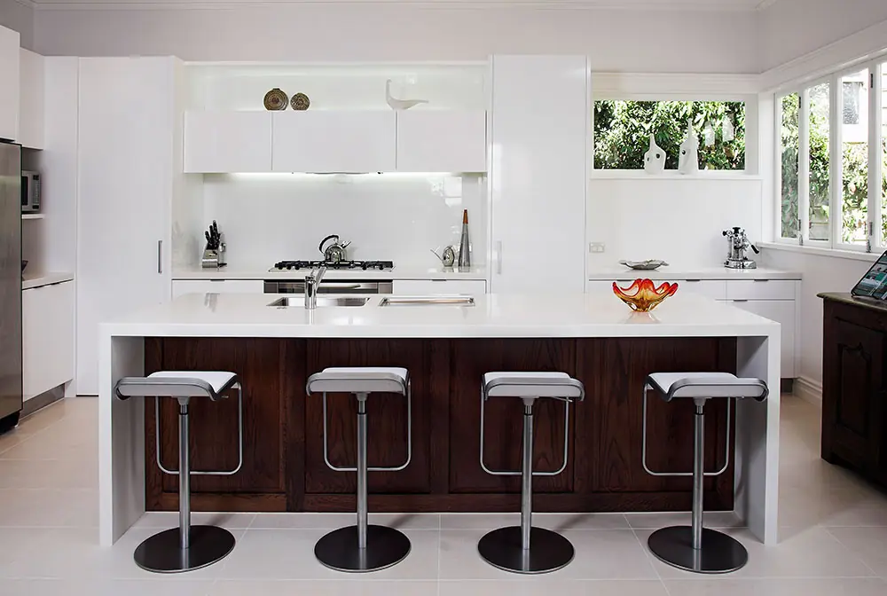Modern Auckland kitchen renovation with a stone-topped island and bar stools