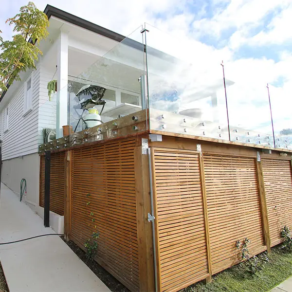 Birkenhead 1950s state house after renovation, with a glass balustrade deck and timber screening