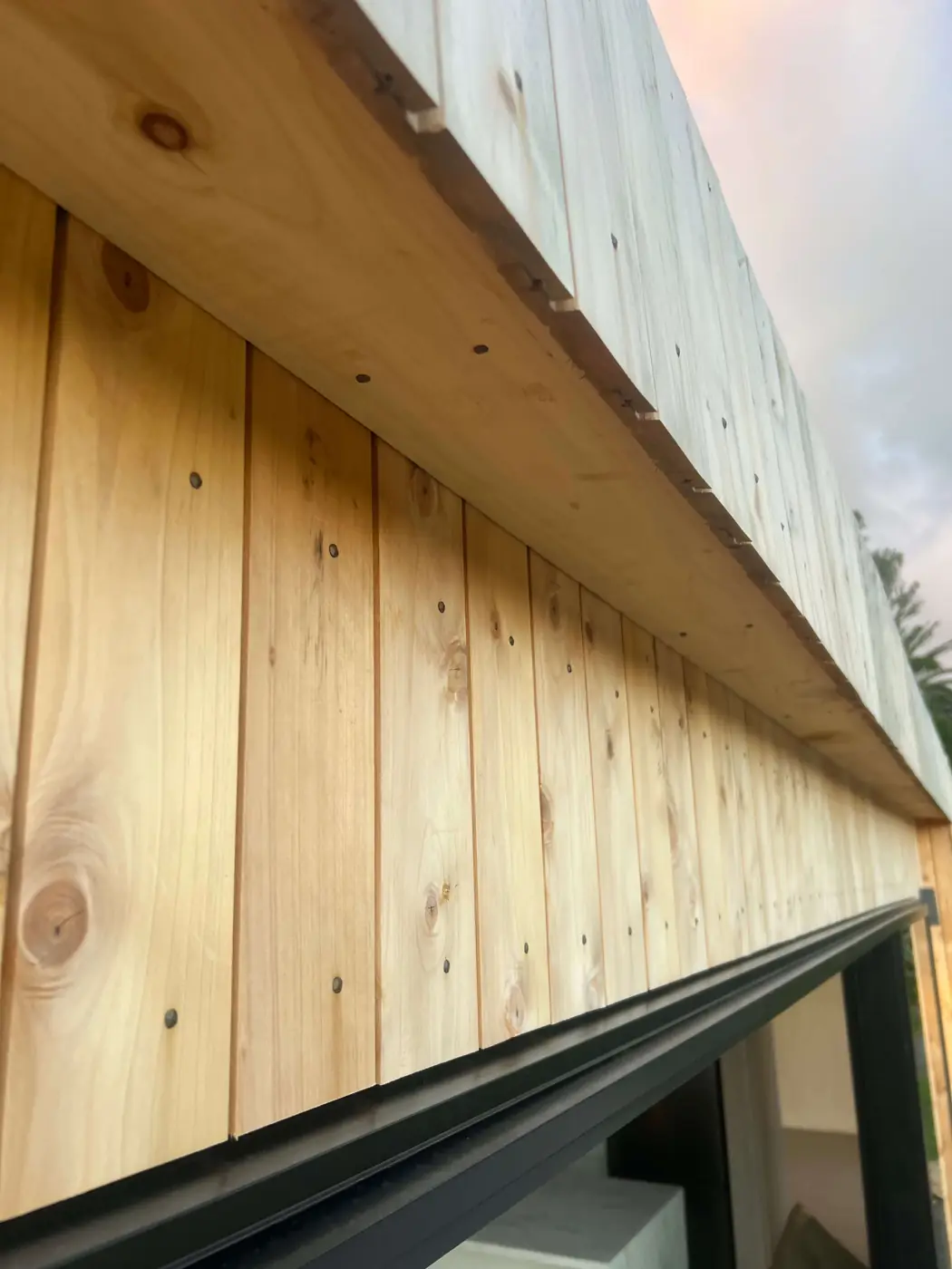Vertical macrocarpa cladding above the joinery of a Fab Living prefab home