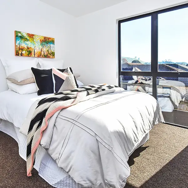 Bedroom with large windows in a new Mangere home