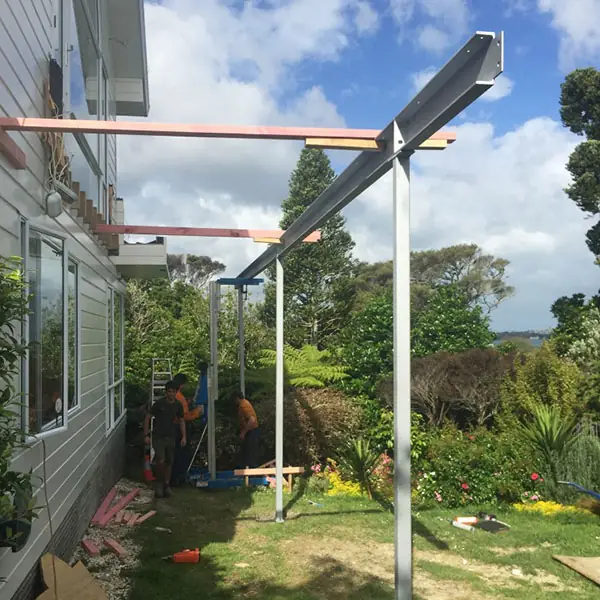 Steel posts and beam going up beside a Northcote Point house, with the harbour behind