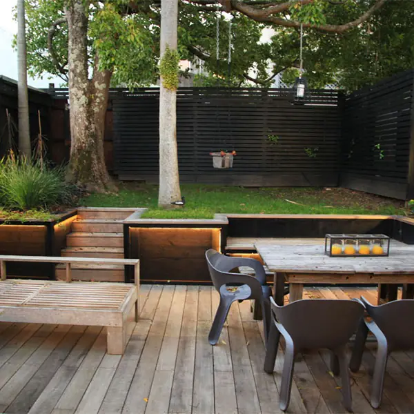 Ponsonby deck after, with an outdoor dining area, timber steps and lit planter boxes