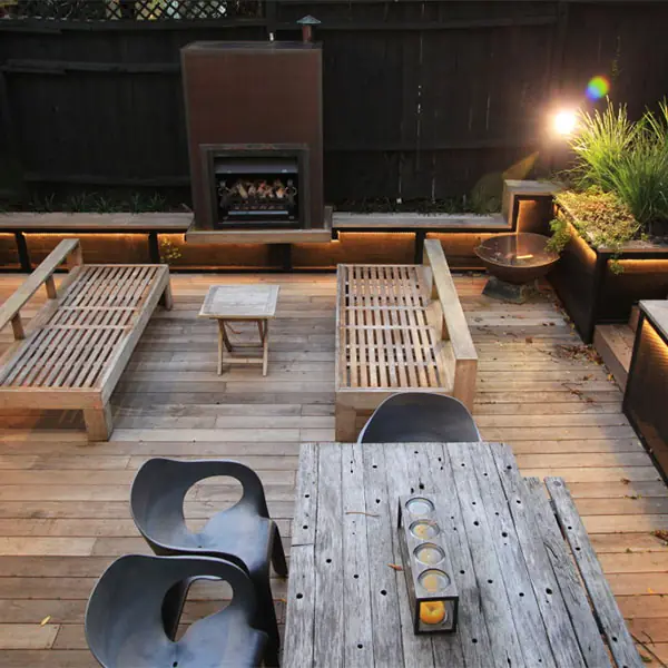 Ponsonby deck after, with built-in timber seating and a custom steel gas fireplace