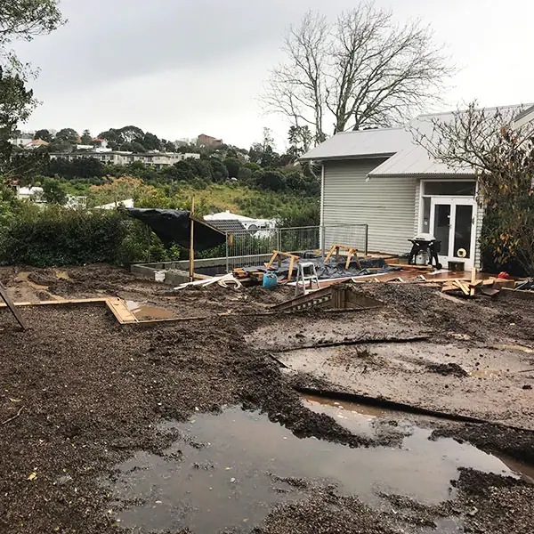 Backyard earthworks for the new lawn and garden at a Remuera bungalow, with the deck under way
