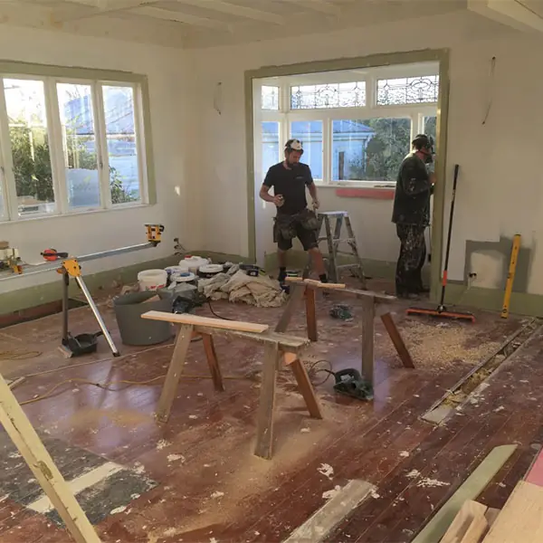 Builders at work in a stripped-back Western Springs living room