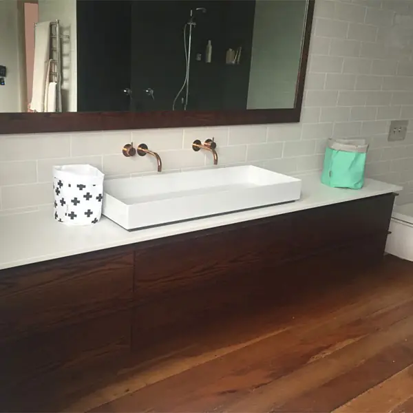 Western Springs bathroom with a long wall-mounted basin on a dark timber vanity